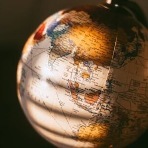 A detailed close-up of a vintage world globe illuminated by warm, soft light.